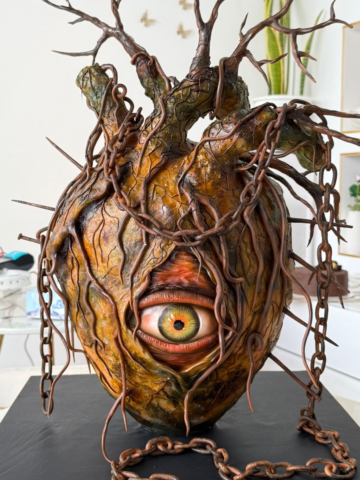 The Hearts Unveiled Vision sculptured cake, with an eye, branches and chain details